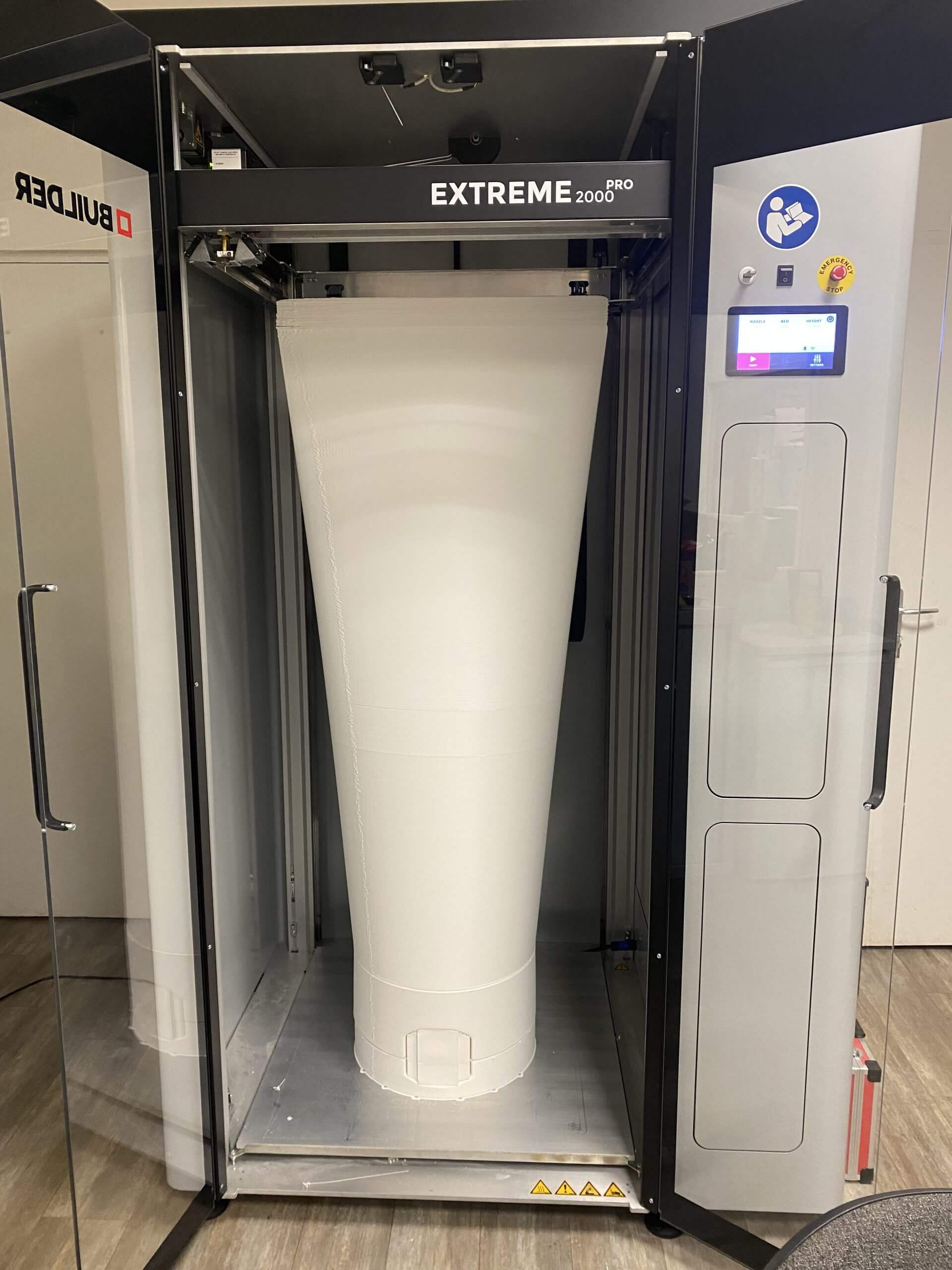 Tube de crème blanc imprimé en 3D grand format, présenté à l'intérieur d'une imprimante 3D industrielle