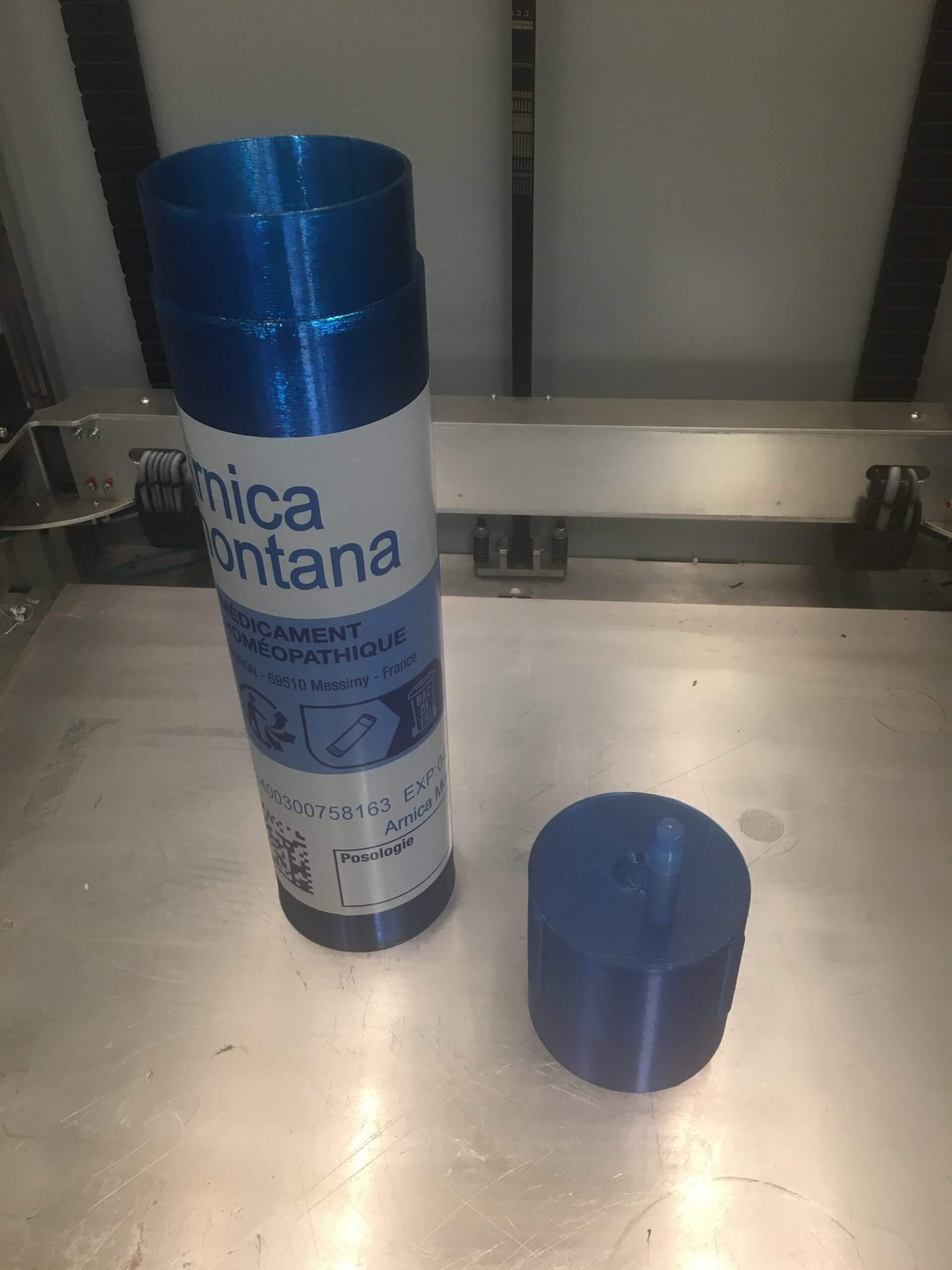 Tube homéopathique bleu imprimé en 3D grand format avec bouchon transparent, présenté sur une surface métallique
