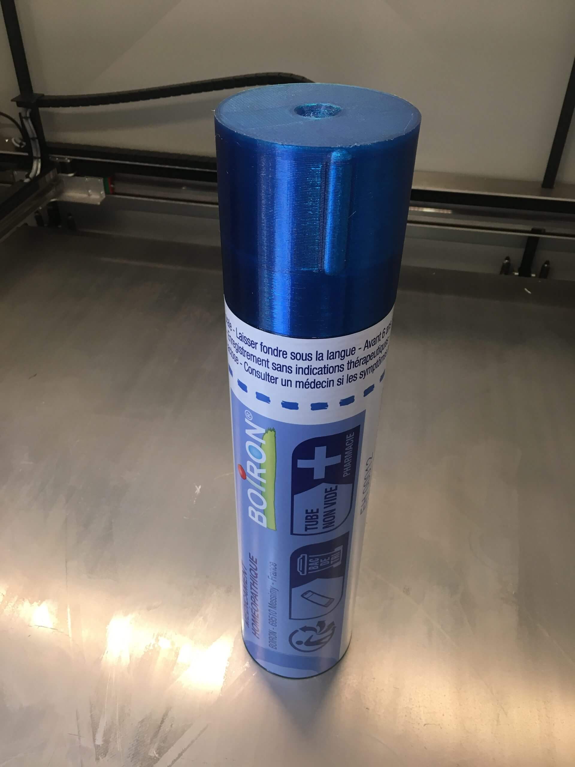 Tube homéopathique bleu imprimé en 3D grand format avec bouchon transparent, présenté sur une surface métallique