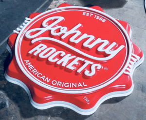 Enseigne thermoformée 3D grand format rouge et blanc avec logo Johnny Rockets, utilisée pour signalétique extérieure.